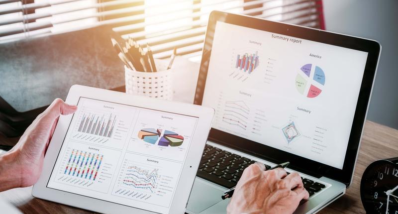 Businessman working with digital tablet and book and document on wooden desk in modern office.Top view Business analysis and strategy concept