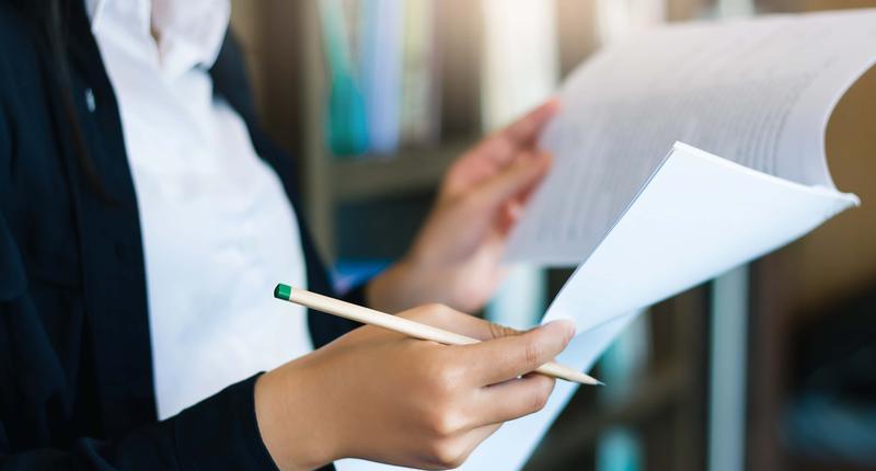 Businesswoman reading information on paperwork or checking bank statement