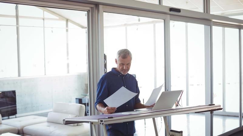 Interior designer analyzing diagrams on papers in office