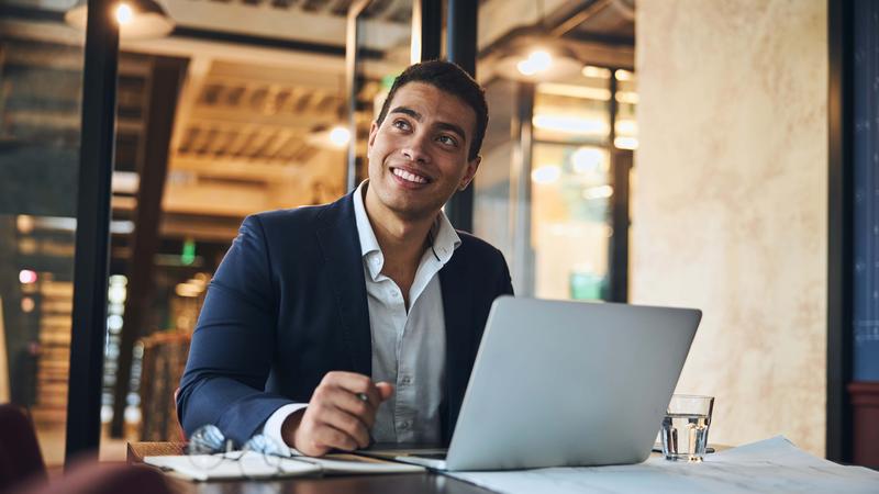 Joyous young draftsman daydreaming in the workplace