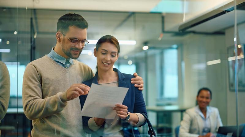 Young couple going through contract they signed with real estate agent in office