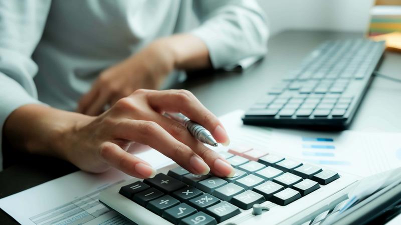 woman is pressing calculator and prepare information for report to correct