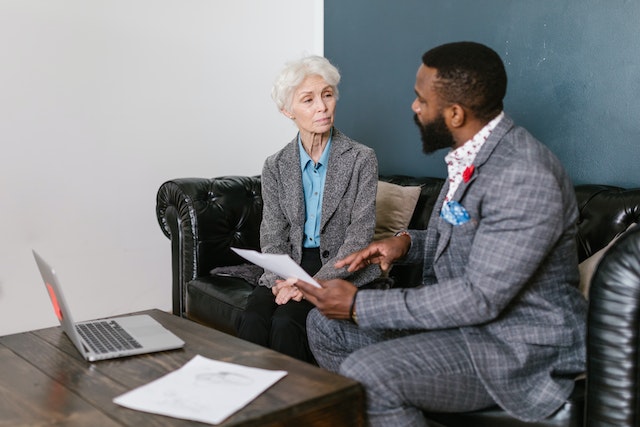 young man in suit looking at documents with older woman